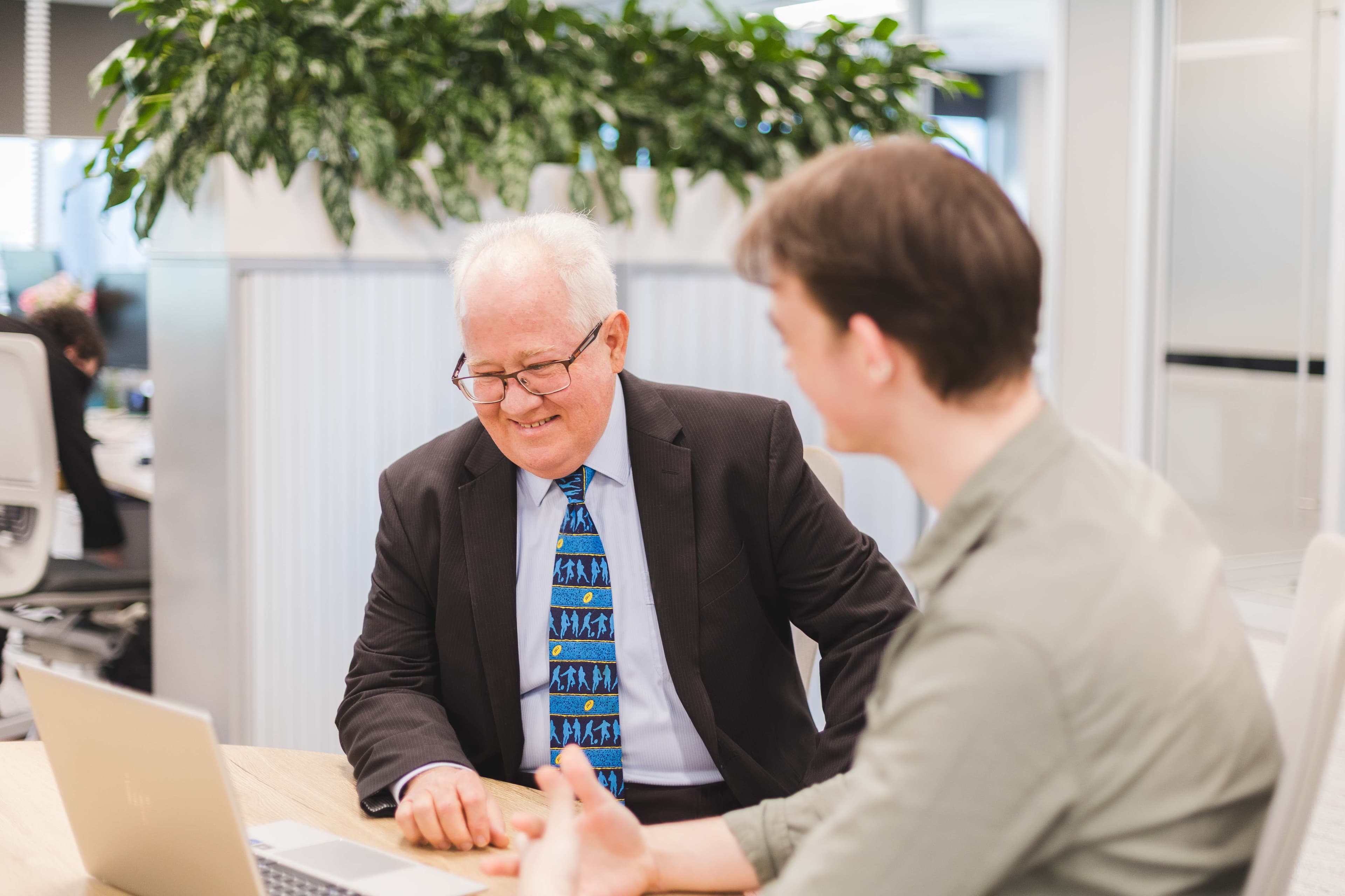 Insurance broker speaking with young insurance broker at QIB Group
