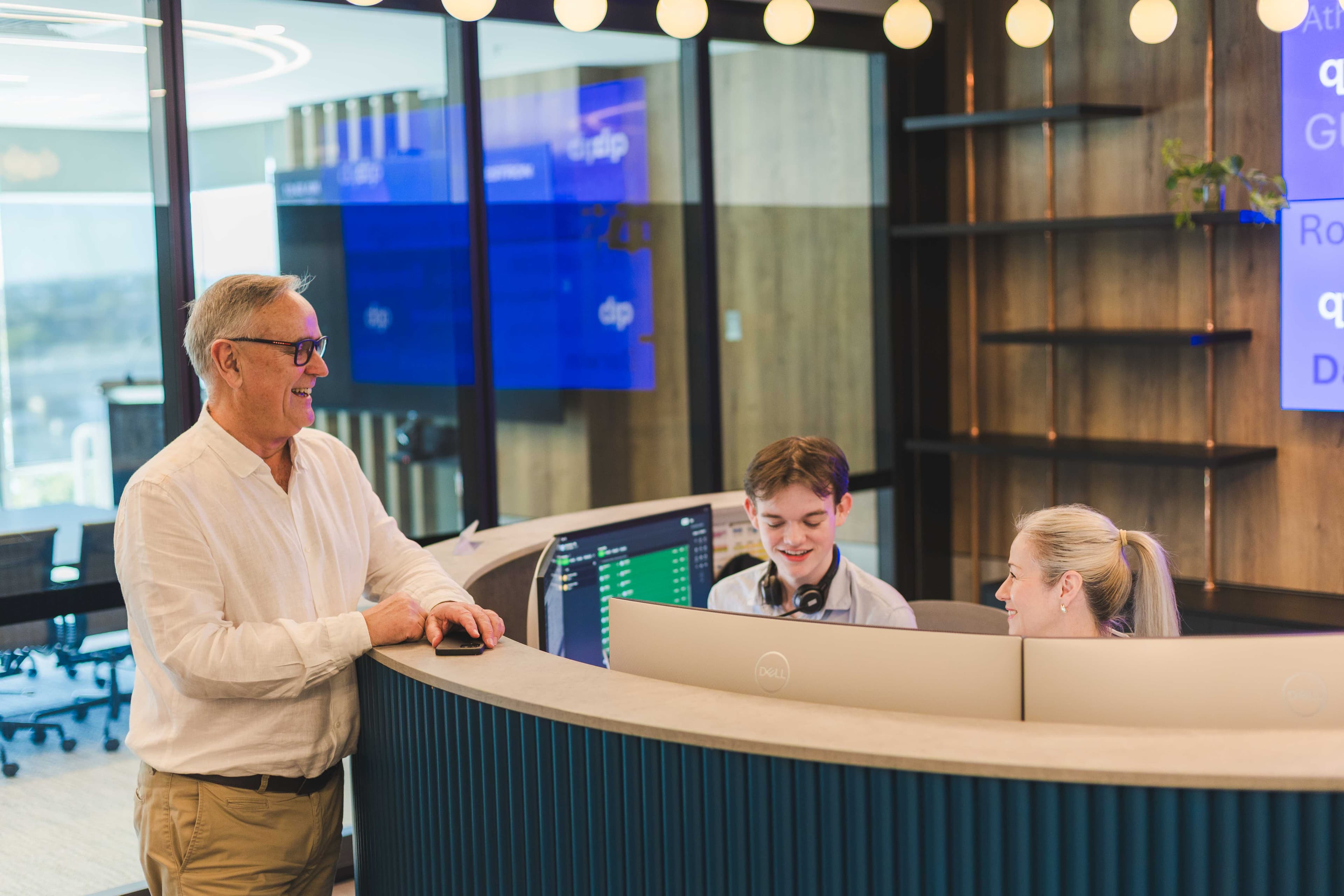 Insurance broker conversing with reception staff at QIB Group Pty Ltd, Brisbane Queensland
